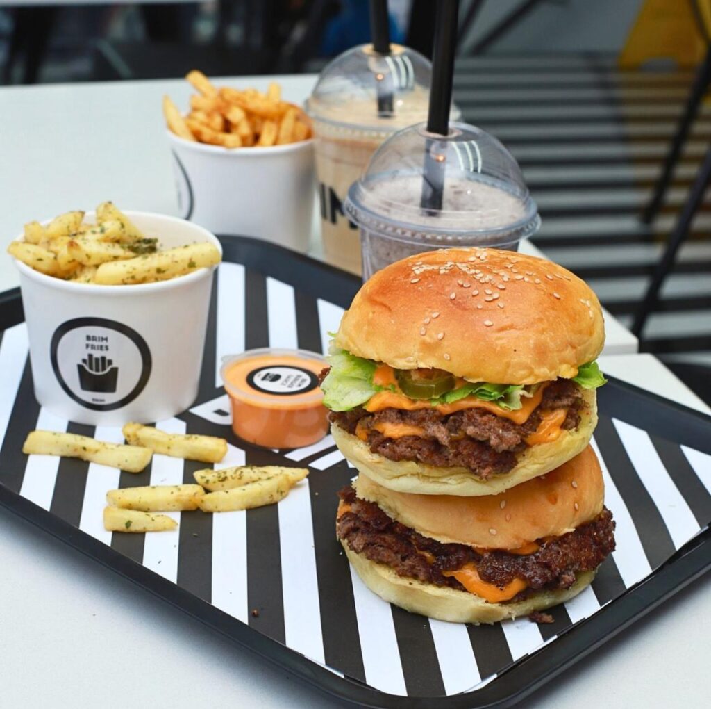 A tray with two burgers and fries on it, ready to be enjoyed.