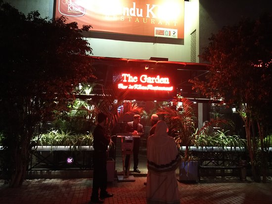 The Garden Restaurant in Lahore: A serene outdoor dining area surrounded by lush greenery and beautiful flowers.